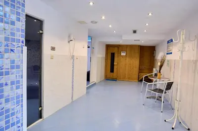 a hallway with a table and chairs in a building at Constantzia Balneohotel in Kostenets Village