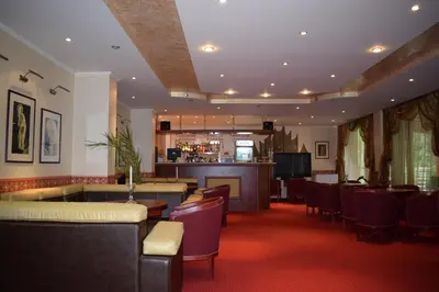 a restaurant with a bar and some chairs and tables at Хотел 
