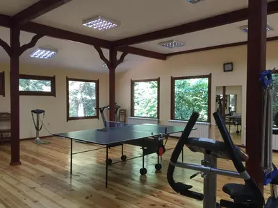 a gym with a ping pong table in a room at Хотел 