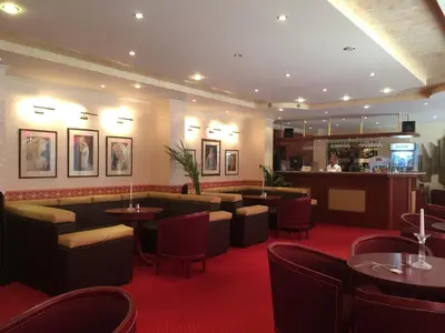 a restaurant with tables and chairs and a bar at Хотел 