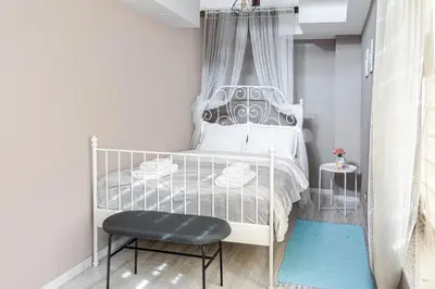a bedroom with a white bed and a chair at The Red Roof House in Plovdiv