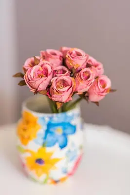 a colorful vase with a bouquet of pink roses at The Red Roof House in Plovdiv