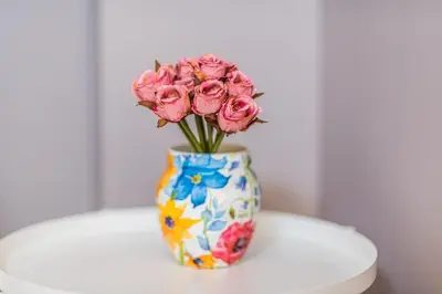 a vase filled with pink roses sitting on a table at The Red Roof House in Plovdiv