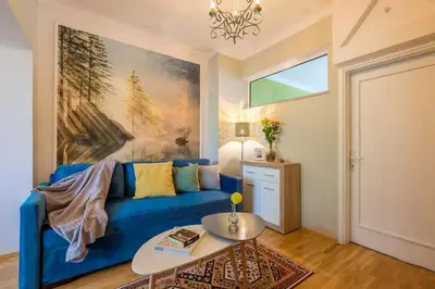 a blue couch in a living room with a painting at FUNKY FRESH place in the heart of Sofia in Sofia