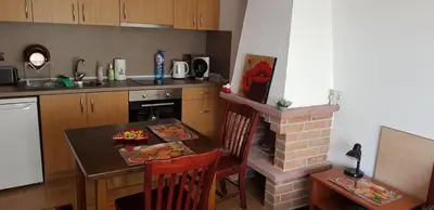 a kitchen with a table and a brick fireplace at Simon's studio in Bansko