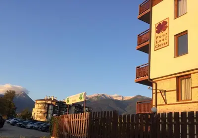 a building with a fence and mountains in the background at Simon's studio in Bansko