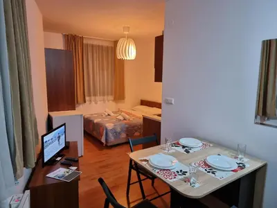 a living room with a table and a bedroom at BanskoSuperSki in Bansko