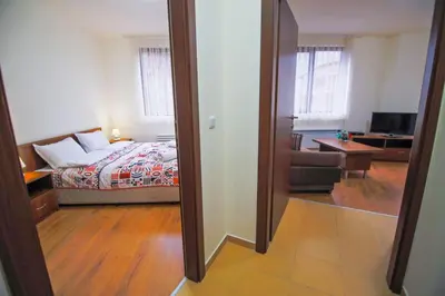 a view of a bedroom with a bed and a living room at BanskoSuperSki in Bansko