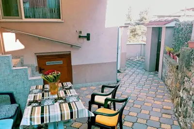 a table with a vase of flowers on a patio at Нouse with cute little yard in Plovdiv