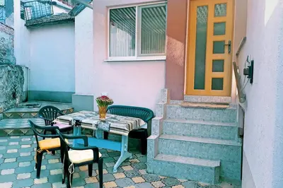 a table and chairs in front of a house at Нouse with cute little yard in Plovdiv