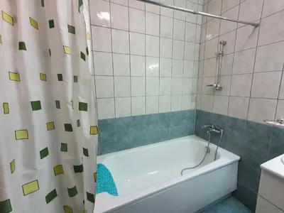 a bathroom with a bath tub and a shower curtain at Flora Apartments TMF in Borovets