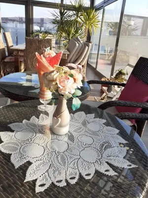 a table with a vase with flowers on it at Alexander Hotel in Asenovgrad