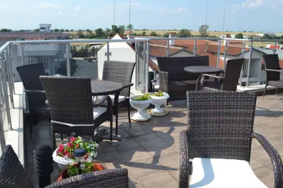 a patio with chairs and a table on a balcony at Alexander Hotel in Asenovgrad