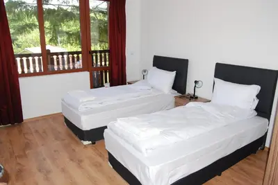 two beds in a room with a window at Vidima Apartment Hotel in Apriltsi