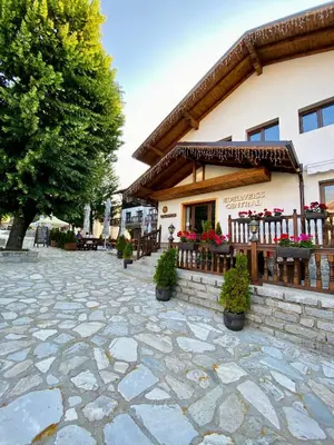 a building with a patio in front of it at Edelweiss Central Hotel in Bansko
