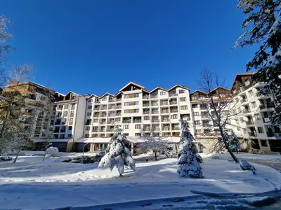 a large apartment building with snow on the ground at Borovets Gardens Apartments TMF in Borovets