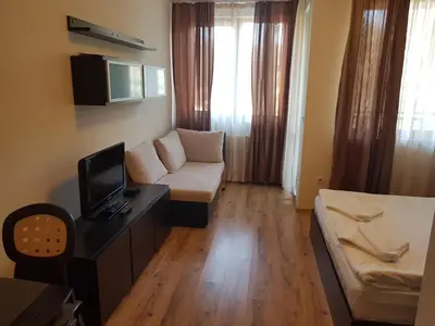 a living room with a couch and a tv at Borovets Gardens Apartments TMF in Borovets