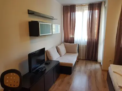 a living room with a couch and a tv at Borovets Gardens Apartments TMF in Borovets