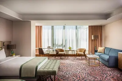 a hotel room with a bed and a living room at Grand Hotel Millennium Sofia in Sofia