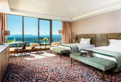 a hotel room with two beds and a large window at Grand Hotel Millennium Sofia in Sofia