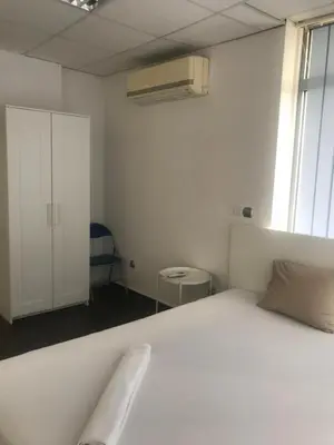 a bedroom with a white bed and a white cabinet at Lilia 5 Self-Check in apartment in Sofia