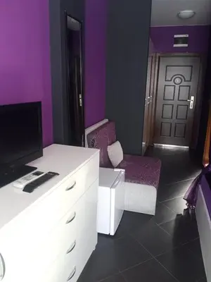 a purple room with a desk and a chair and a door at Бора Бора in Sapareva Banya