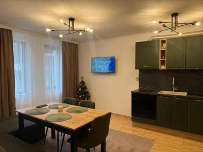 a kitchen and dining room with a table and a christmas tree at Пампорово , Манастира 3 in Pamporovo
