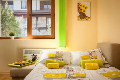 a bedroom with a bed with yellow and green accents at Green Lime Studio in Bansko