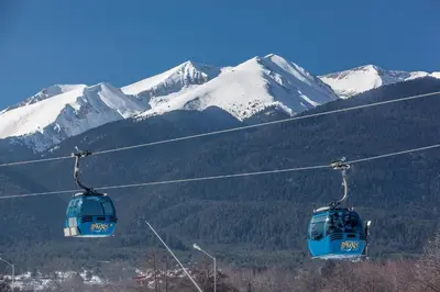 two gondolas on a ski lift with snow covered mountains at Green Lime Studio in Bansko