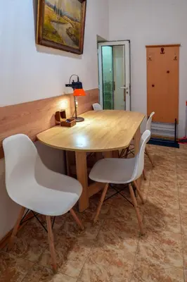 a wooden table with white chairs in a room at Central Halls apartment in Sofia