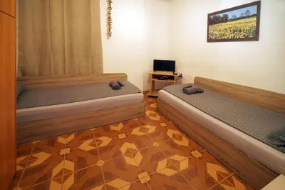 a room with two beds and a television in it at Central Halls apartment in Sofia