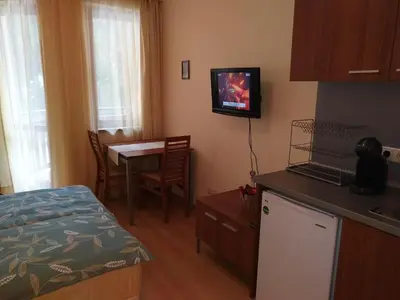 a small room with a kitchen and a table with a television at Studio Villa Park 207 in Borovets