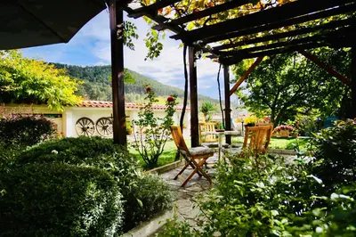 a patio with a table and chairs in a garden at Iliikova House in Kalofer