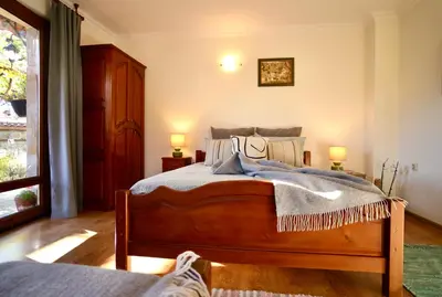 a bedroom with a bed and two lamps and a window at Iliikova House in Kalofer