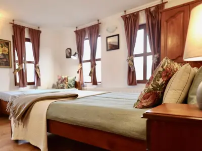 a bedroom with a large bed with windows at Iliikova House in Kalofer