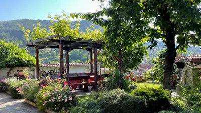 a bench in a gazebo in a garden at Iliikova House in Kalofer