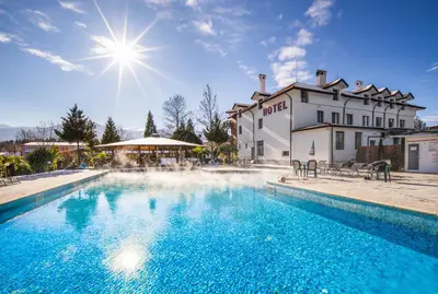a swimming pool in front of a building at Dolna Bania Hotel in Dolna Banya