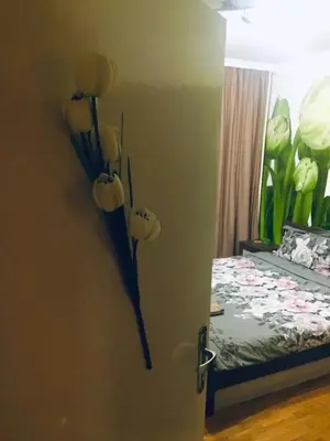 a door with flowers on the wall next to a bed at Tulips - Room for travelers, close to the Airport, transport possible in Sofia