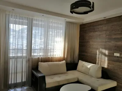 a living room with a couch and a window at Апартамент Легал in Chepelare