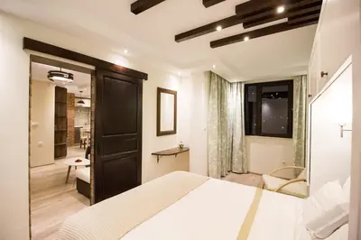 a bedroom with a large white bed and a bathroom at Апартамент Легал in Chepelare