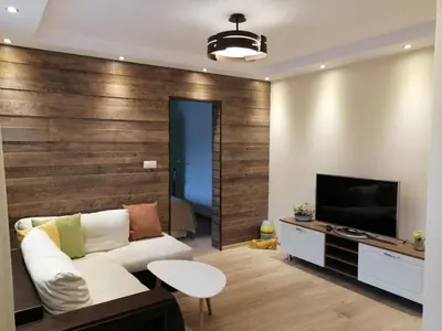 a living room with a white couch and a television at Апартамент Легал in Chepelare