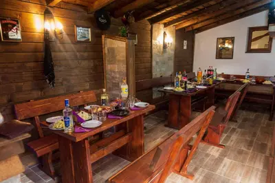 a dining room with wooden tables and benches at Guest House Markovi in Govedartsi