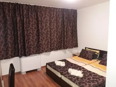 a bedroom with two beds and a curtain at КЪЩА ЗА ГОСТИ ХАРМОНИ in Shiroki Dol