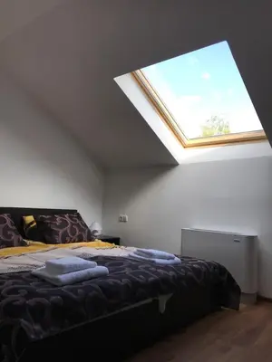 a bedroom with a bed with a large skylight at КЪЩА ЗА ГОСТИ ХАРМОНИ in Shiroki Dol