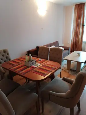 a living room with a wooden table and chairs at Evrika home 5 in Pamporovo