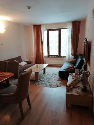a living room with a couch and a table at Evrika home 5 in Pamporovo