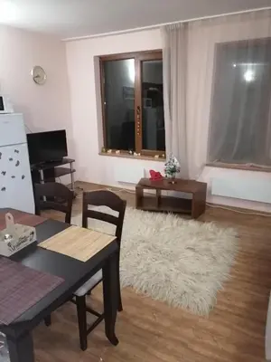 a living room with a table and a white rug at Evrika home 19 in Pamporovo