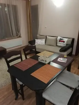 a living room with a table and a couch at Evrika home 19 in Pamporovo