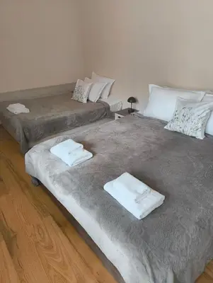 two beds in a room with white towels on them at Evrika home 19 in Pamporovo