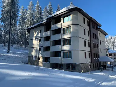 a apartment building in the snow in the woods at Evrika home 19 in Pamporovo